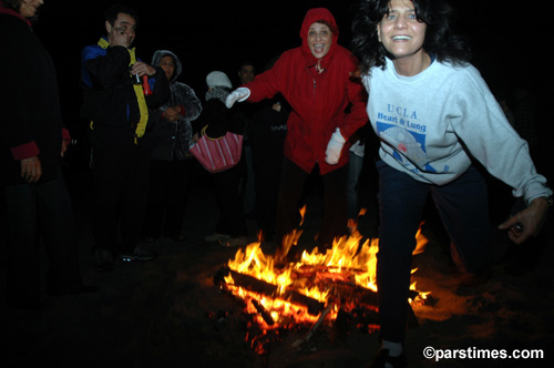 Women jumping over the bonfire (March 14, 2006) - by QH