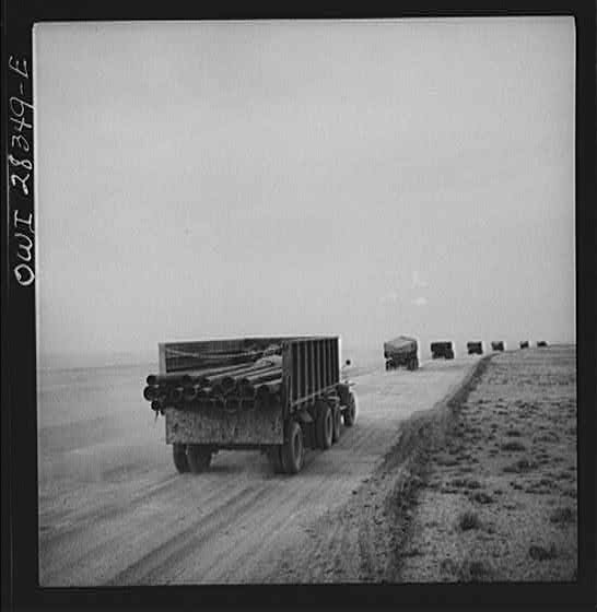 Somewhere in the Persian corridor. A United States Army truck convoy carrying supplies for Russia moving on a desert road.