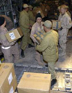 Bam Earthquake Relief: Senior Airman Lindsey Whicker hands a box of water to an Iranian soldier here Dec. 28 as part of humanitarian relief efforts - US Air Force